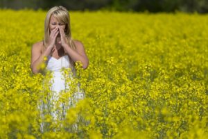 19238500 - a blonde model in a field of flowers with allergies