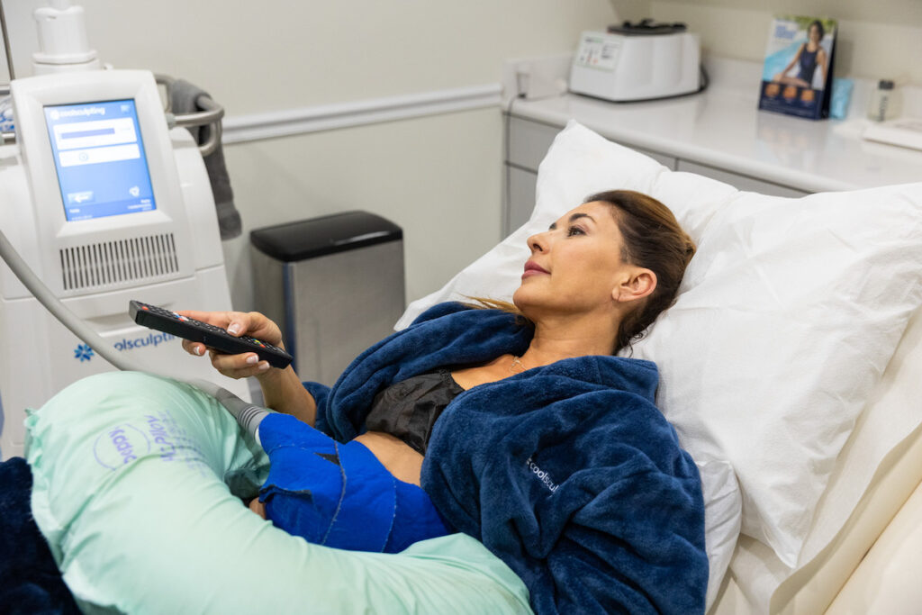 A woman is lying down during her Coolsculpting treatment for body contouring in Tampa.