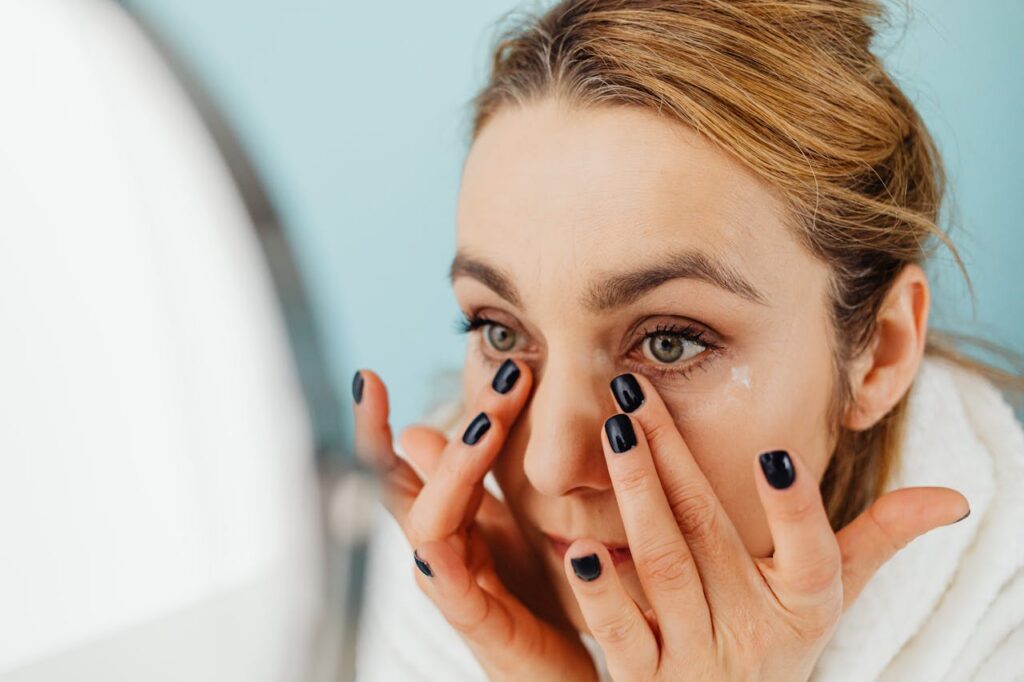 A patient looks in the mirror at her dark circles, contemplating under-eye filler in St. Petersburg.