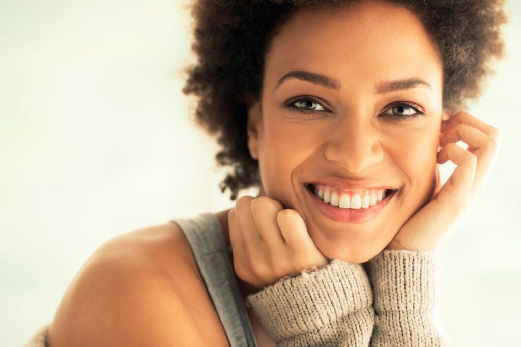 A patient smiles, her youthful features glowing after under-eye filler in St. Petersburg.